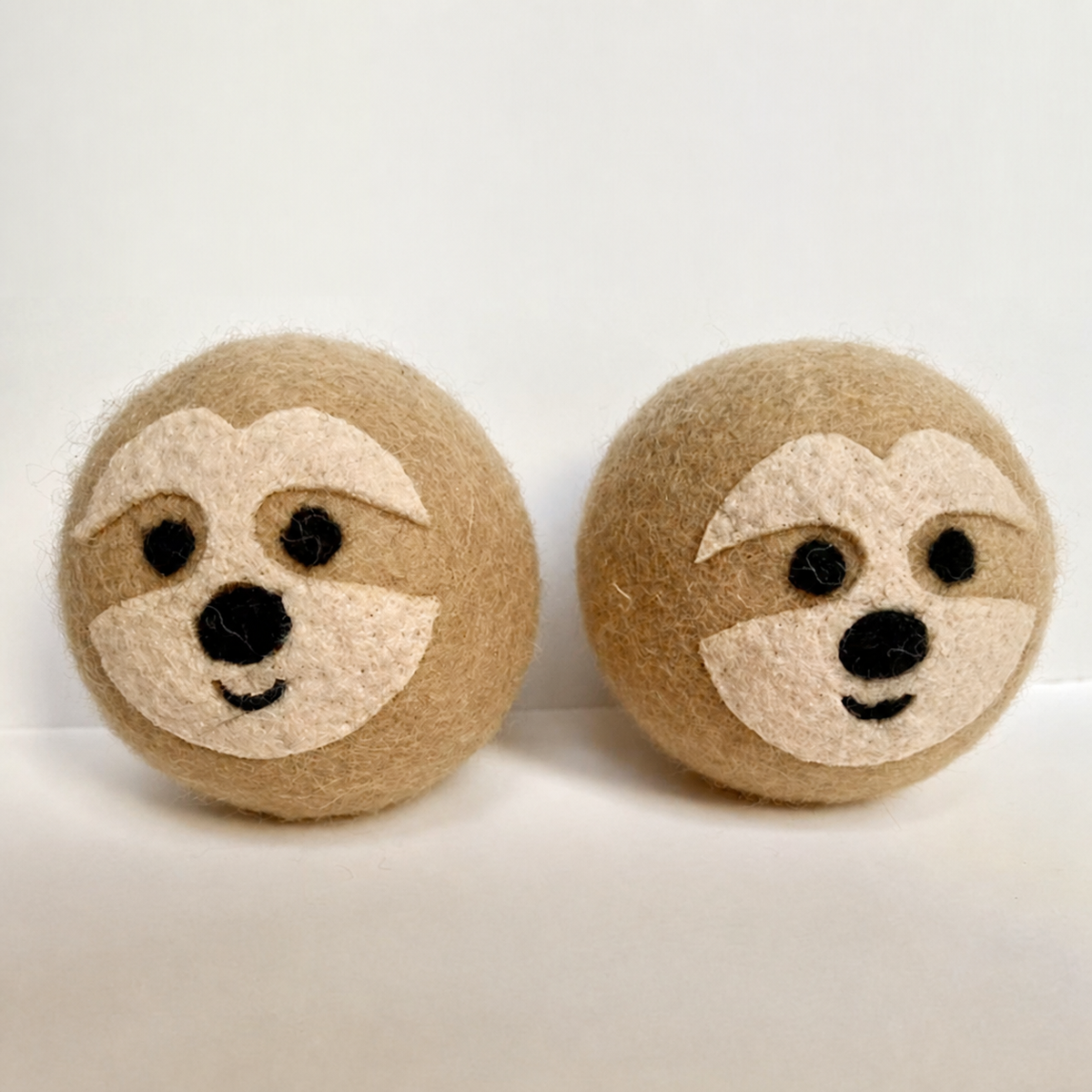 Classic Sloth reusable wool dryer balls on a clean neutral background